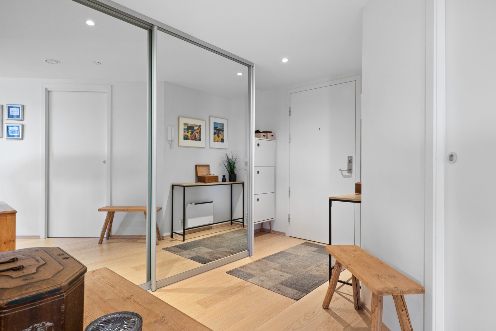 Vel inne blir vi ønsket velkommen i en pen entré med hvitmalte vegger, downlights i himlingen og gyllen parkett på gulvet Galleribilde