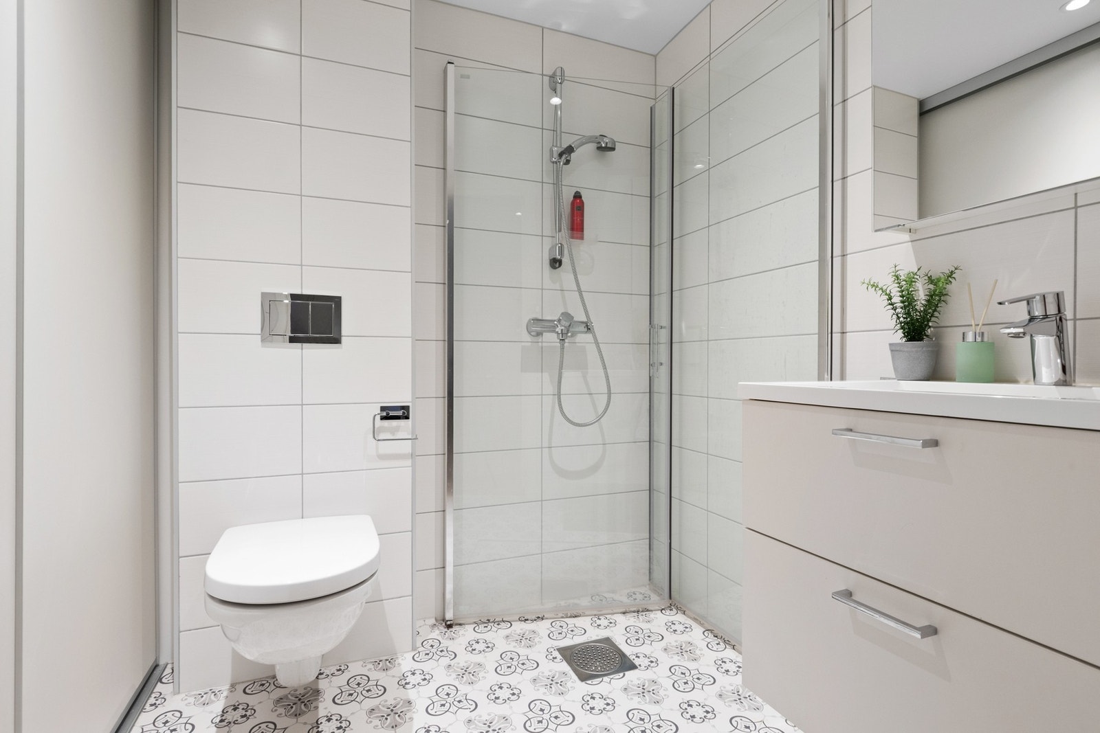 I hendig tilknytning til entreen er det et pent bad/wc med hvite fliser på veggene, downlights i himlingen og oppgraderte mønstrede fliser på gulv med gulvvarme Galleribilde