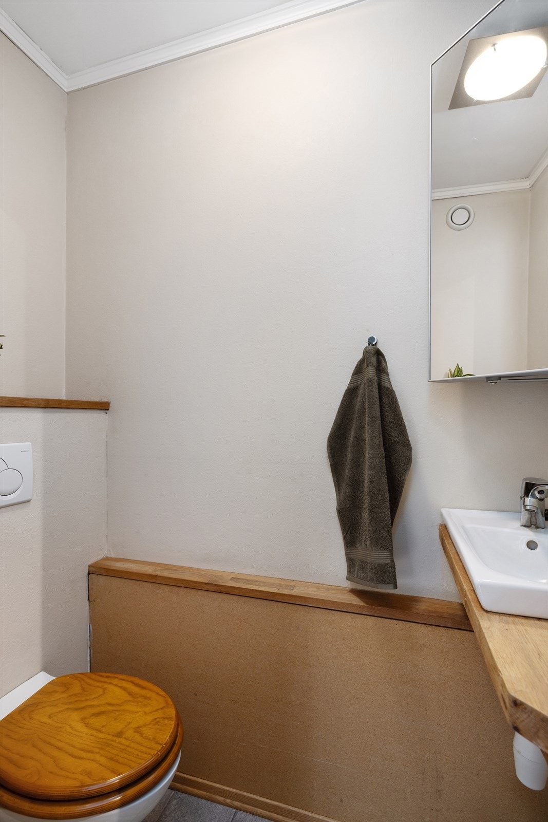 Separat toalettrom med gulvvarme, vegghengt toalett og servant med benkeplate i heltre. Galleribilde