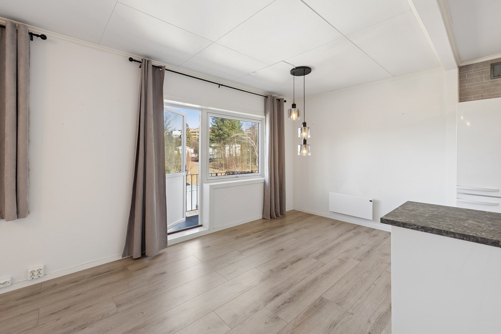 Det er utgang fra stuen til den nordvendte balkongen, via balkongdør med stort glassfelt Galleribilde