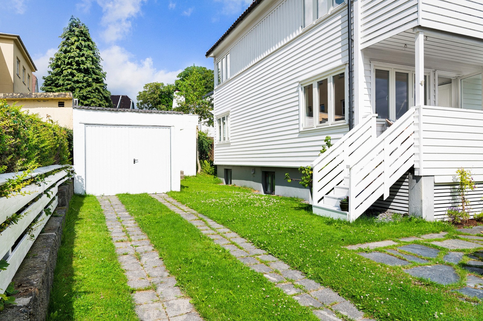 Foran garasjen er det et hellelagt område med mulighet for parkering. Galleribilde