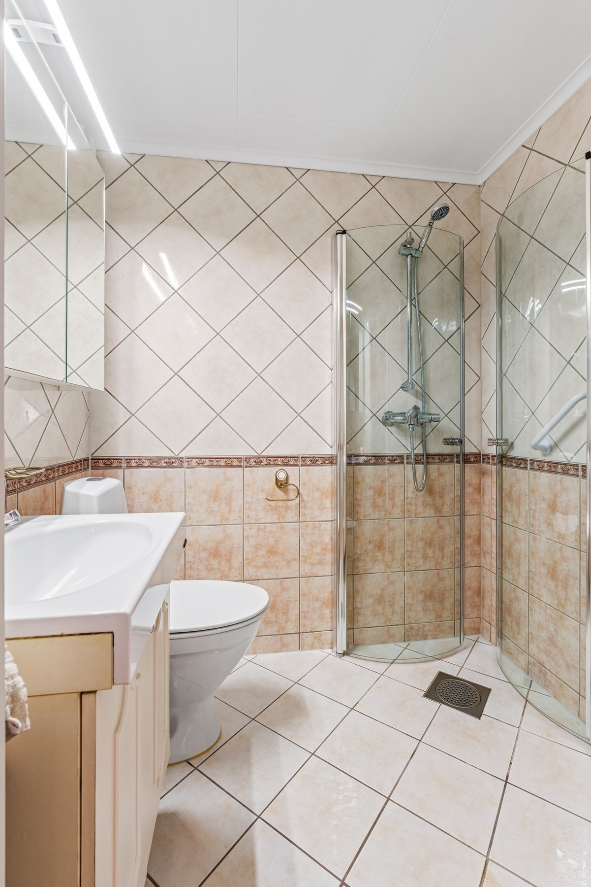 Badet ble pusset opp i ca. 2005, og er utstyrt med toalett, varme i gulv, sensorvifte og et dusjhjørne med to skyvbare buede glassdører. Galleribilde