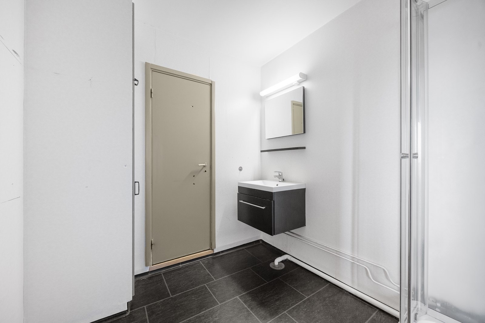 Baderommet har vinylbelegg på gulv, våtromstapet/belegg på vegger og malt betong i tak. Det er mekanisk avtrekk via felles avtrekksanlegg. Galleribilde