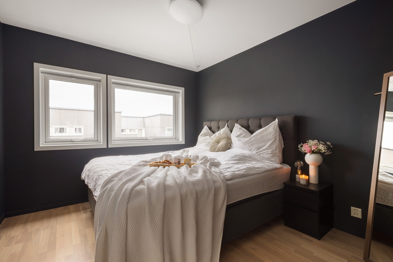 Stilfullt soverom med en rolig og eksklusiv fargepalett i mørke toner. Rommet gir en lun og behagelig atmosfære, perfekt for hvile og avslapning. Galleribilde