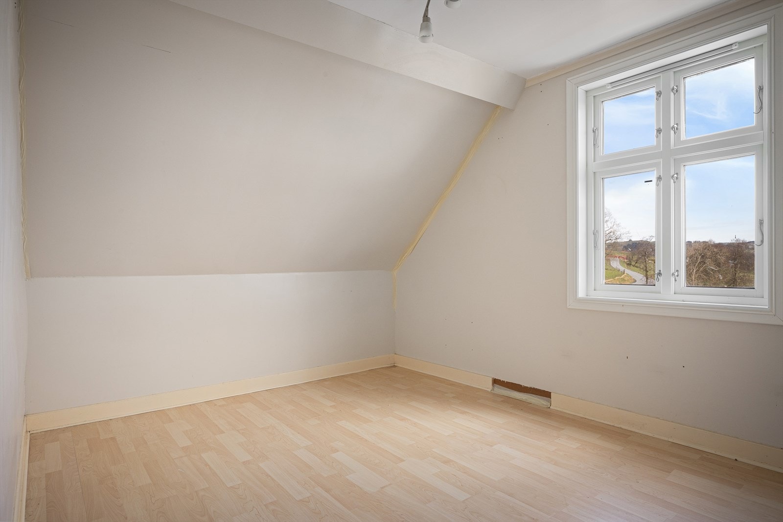 Rom under skråtak i andre etasje, med godt lysinnslipp fra vinduet. Galleribilde