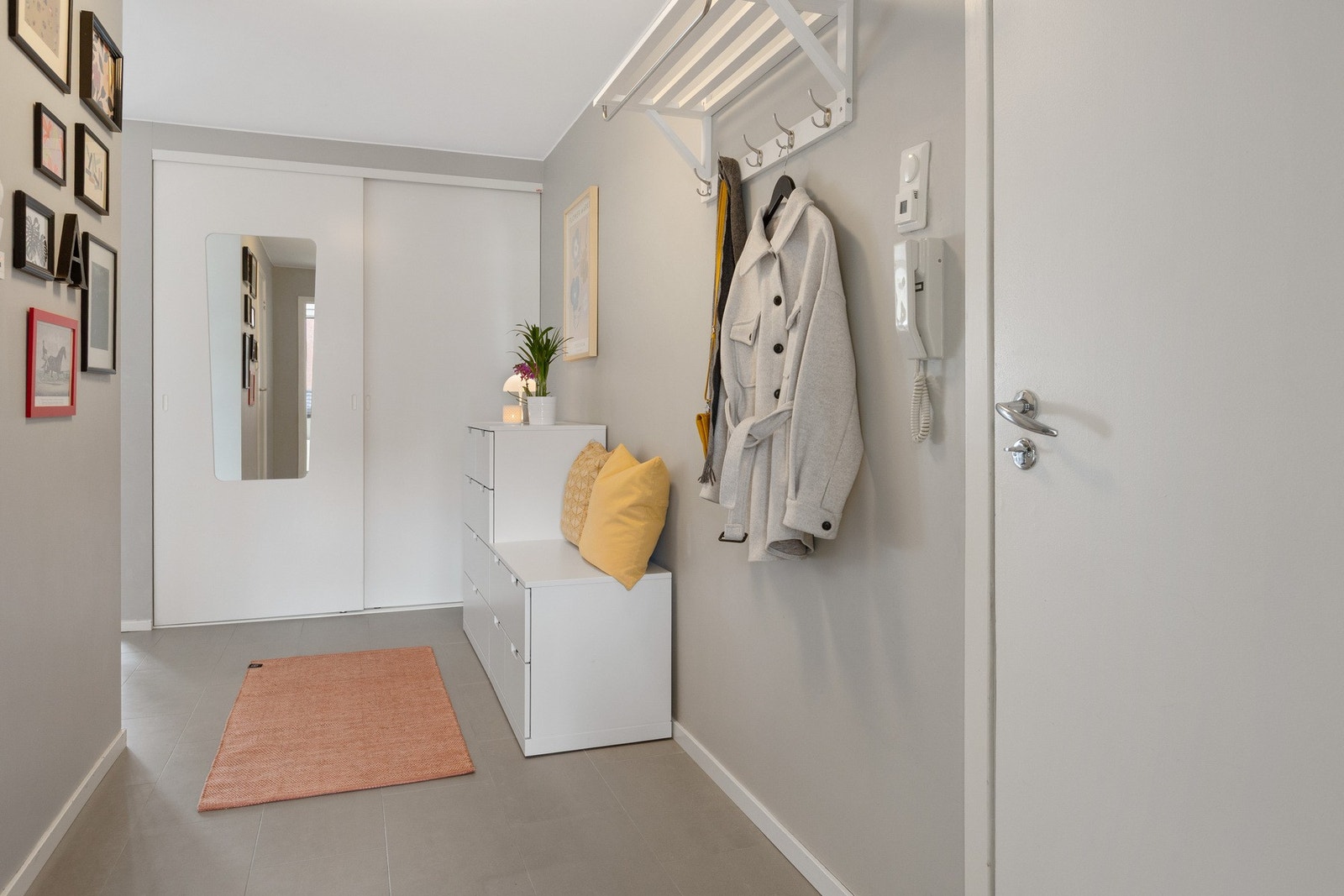 Entréen har flislagt gulv med varme og romslig skyvedørsgarderobe med speil. Galleribilde