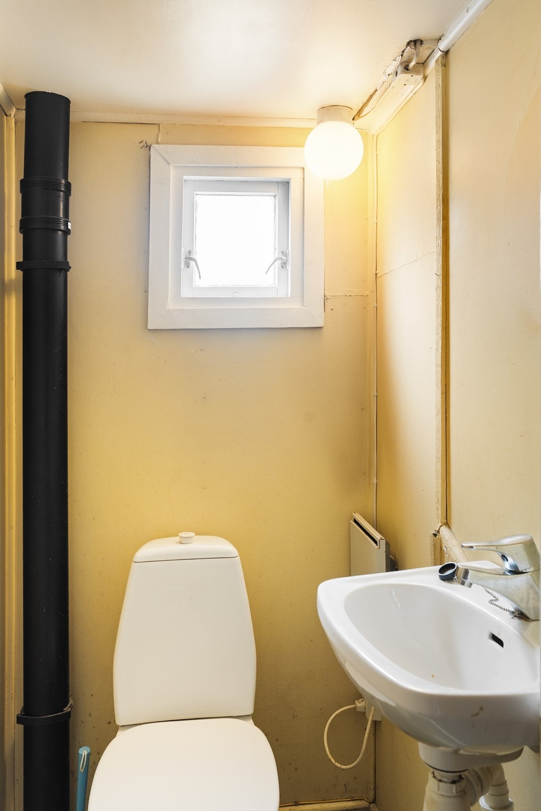 Toalettrom i 1. etasje med frittstående toalett og enkel servant. Galleribilde