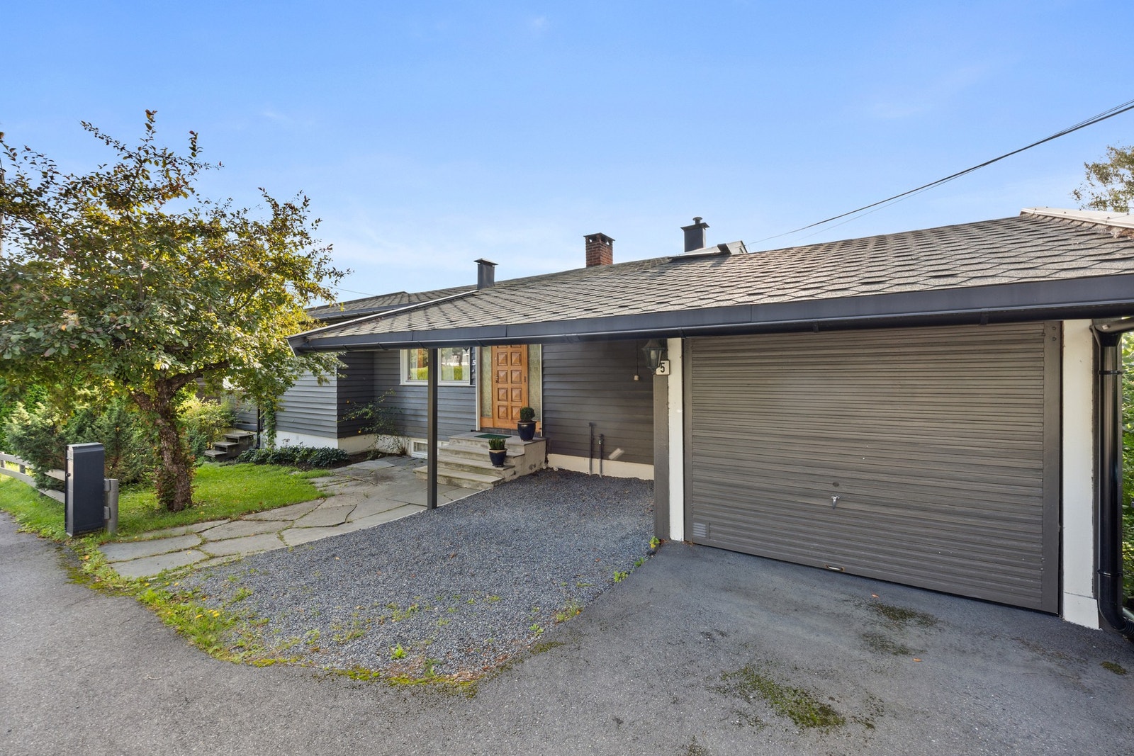Det er parkering for en bil i carport og en bil i garasjen. Galleribilde
