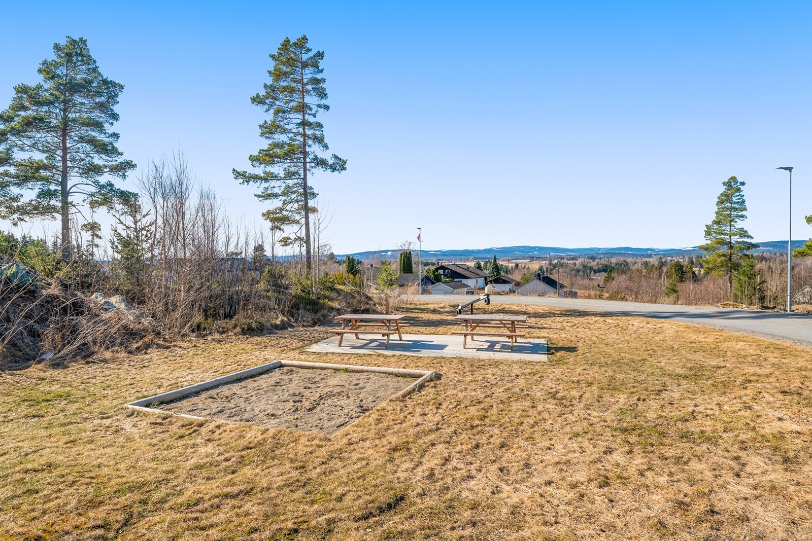 Felles lekeplass med sittegrupper, sandkasse og dumphuske. Galleribilde