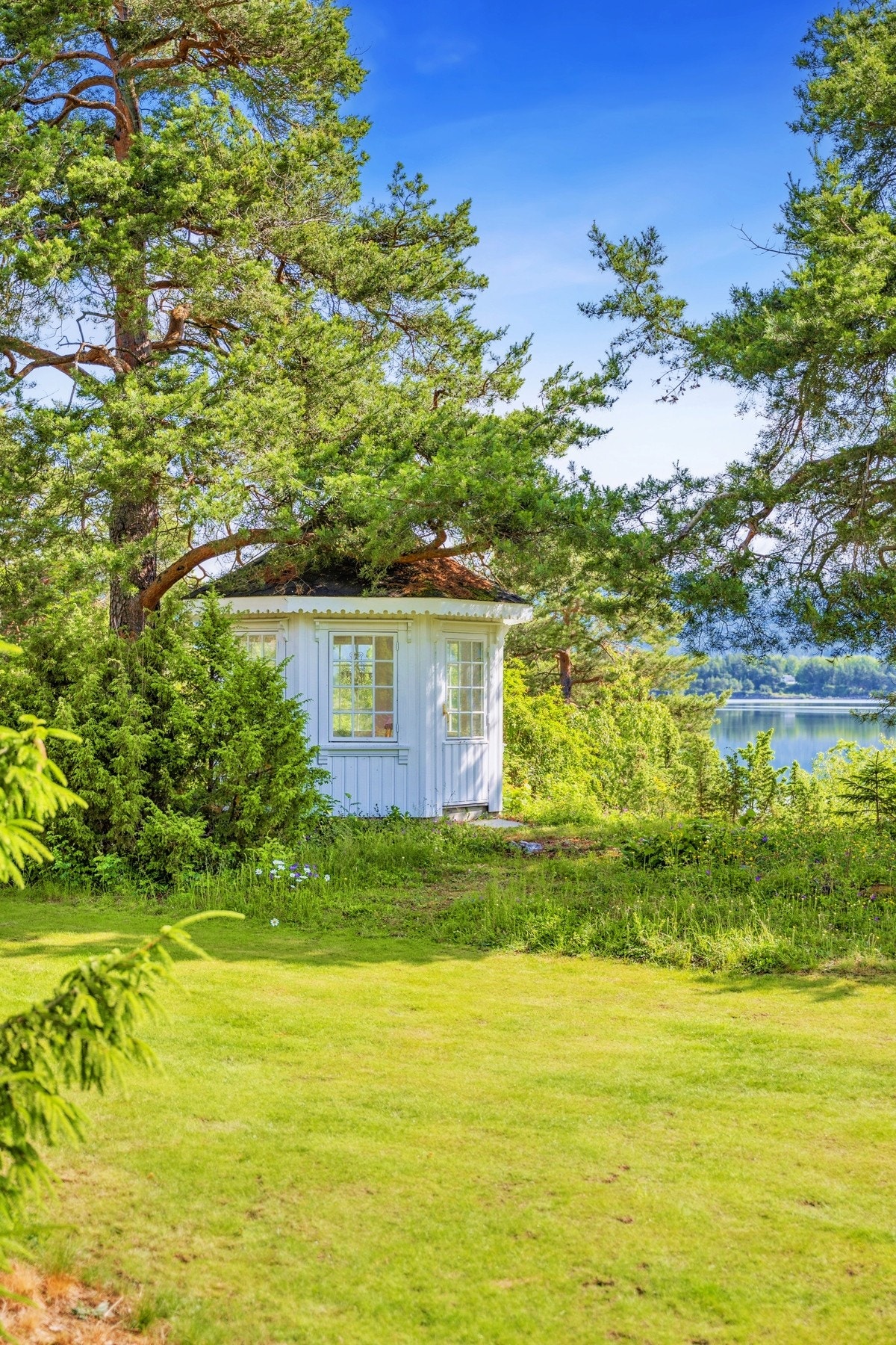 Ned mot vannkanten ligger et sjarmerende lysthus. Galleribilde