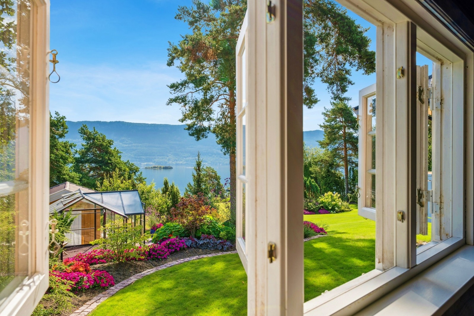 Utsikten vender mot en velstelt hage med flotte blomsterbed. Galleribilde