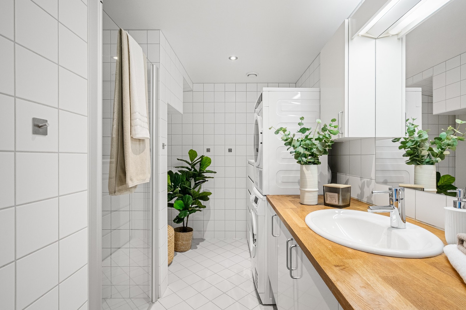 Badet er romslig og har egen dusjnisje med regndusj, samt opplegg for vaskemaskin og tørketrommel Galleribilde