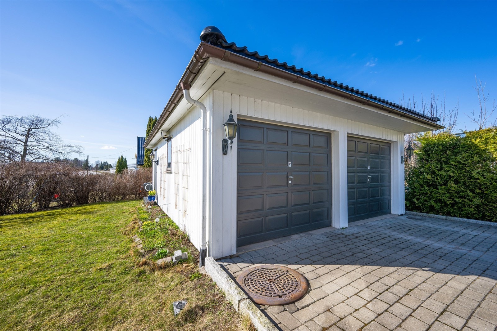 Frittliggende dobbeltgarasje på 45 m² med leddheisporter gir rikelig med plass til biler og lagring. Galleribilde
