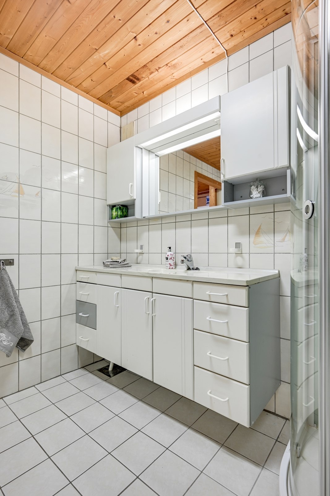 Badet i kjelleren har flislagte overflater og er utstyrt med dusjkabinett og servantinnredning. Galleribilde
