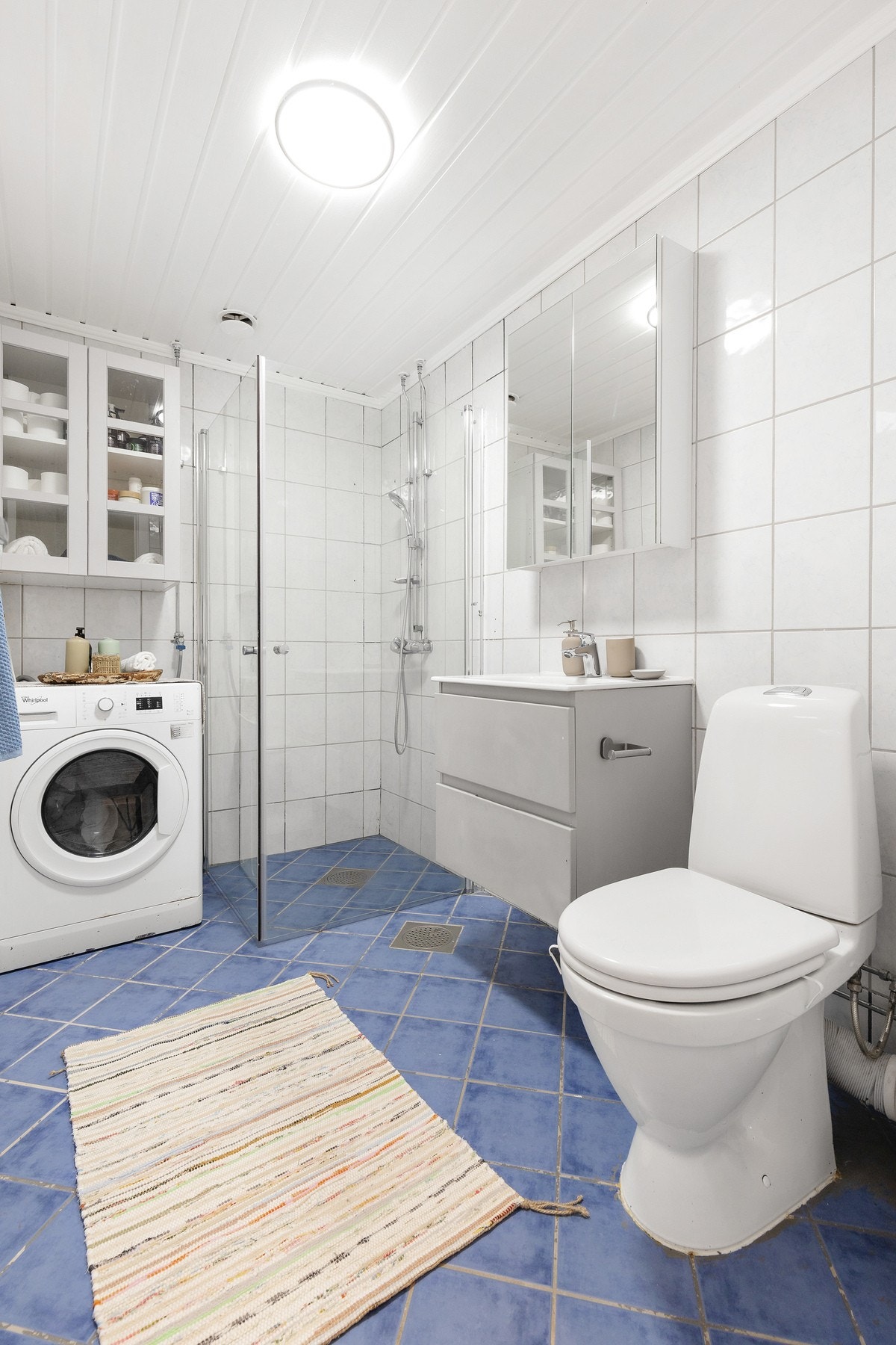 Badet har nedfelt servant med underskap og speilskap over, som gir praktisk oppbevaringsplass i et ryddig og funksjonelt og ryddig baderom. Galleribilde