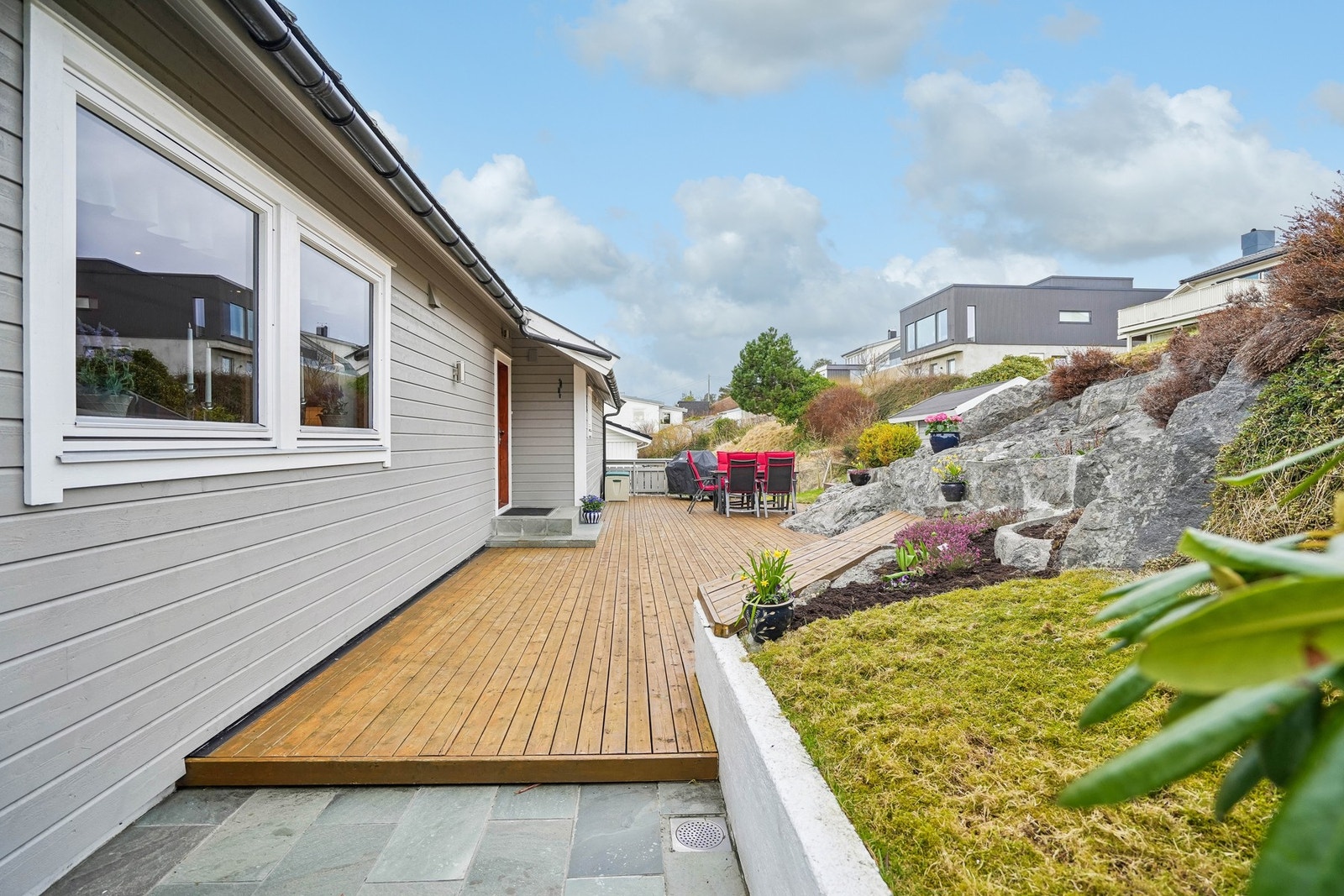 En lun og innbydende terrasse med flere sitteplasser og pent opparbeidede omgivelser. Galleribilde