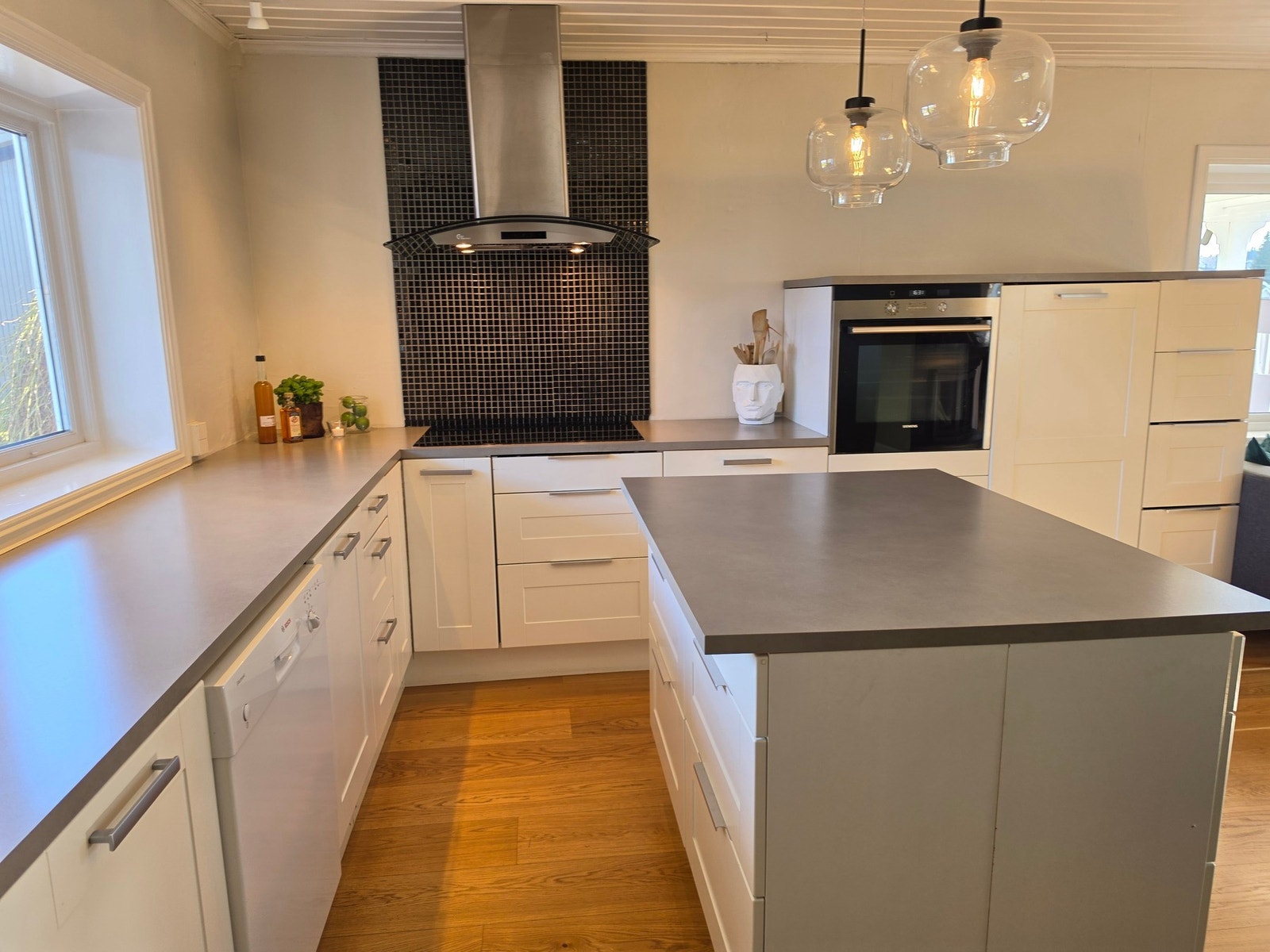 Vinduer på tre sider bidrar med mye naturlig lys til matlagingen. Galleribilde