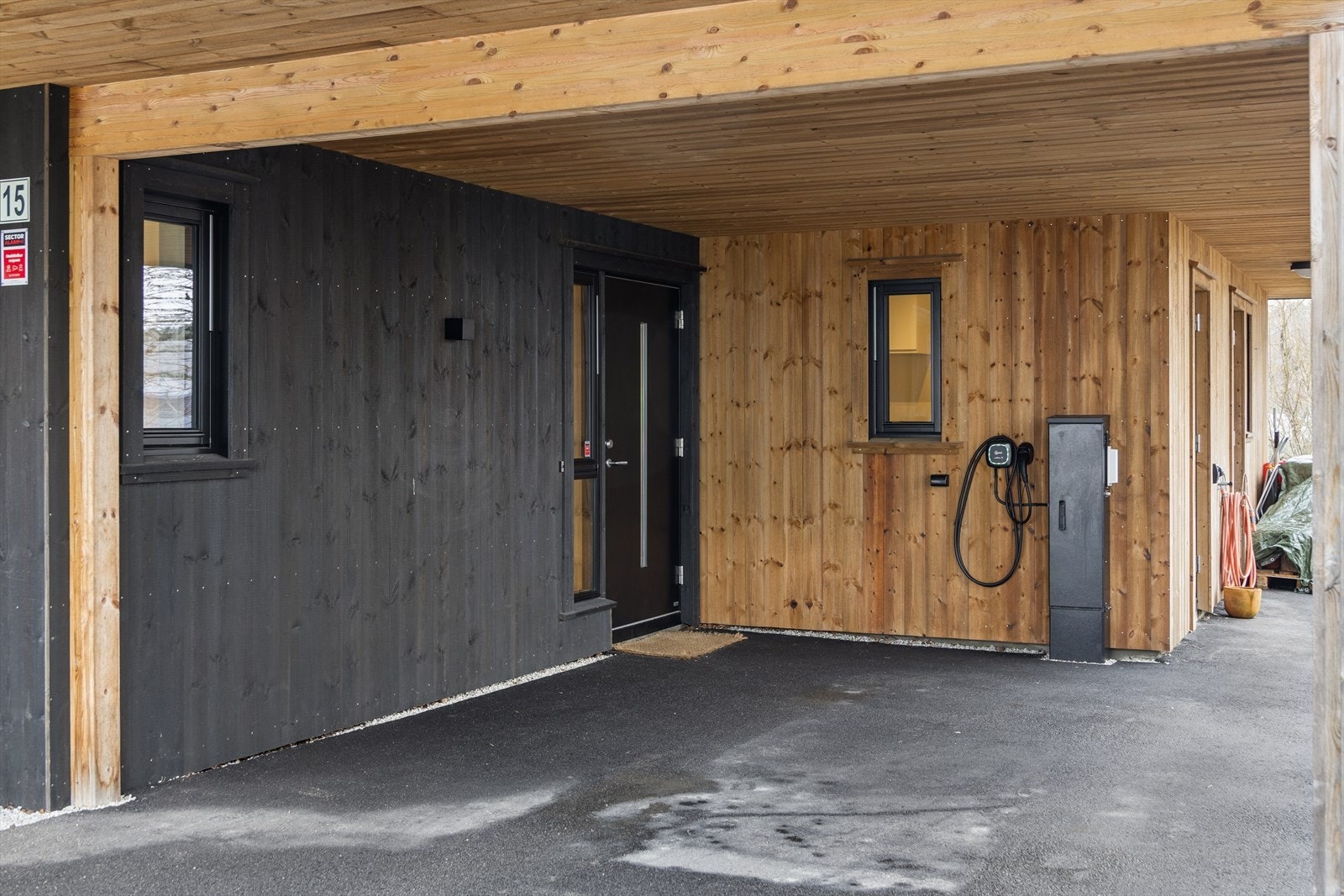 Tilknyttet carport med installert elbillader. Her er også inngang til en isolert, utvendig bod på 7 m². Galleribilde
