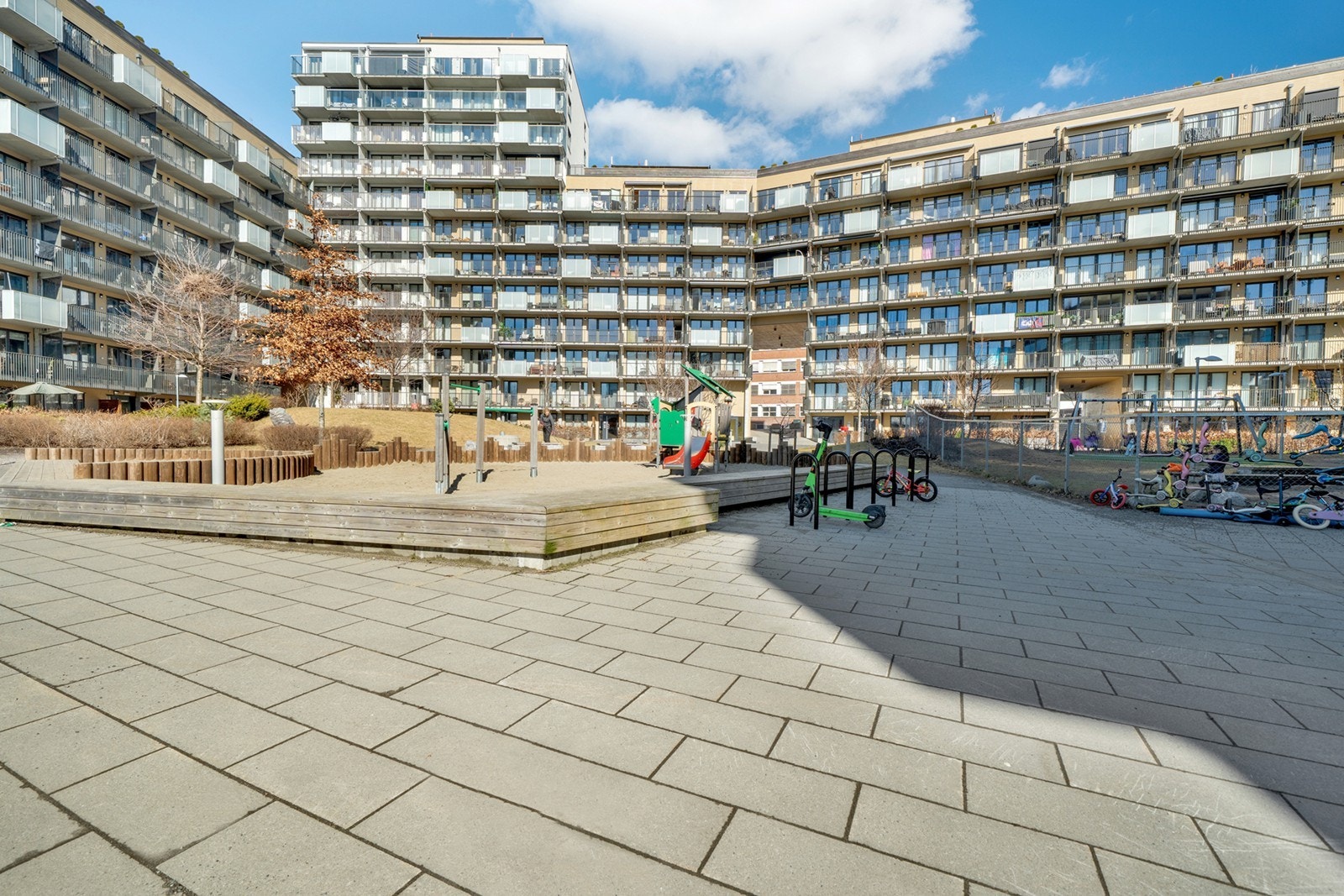 Tomten fremstår som felles, opparbeidet og tilrettelagt for boligformål, med interne utearealer mellom bygningsmassene. Arealene er i hovedsak opparbeidet med belegningsstein, gressarealer, beplantning og mindre trær, som gir et helhetlig & ryddig utt Galleribilde