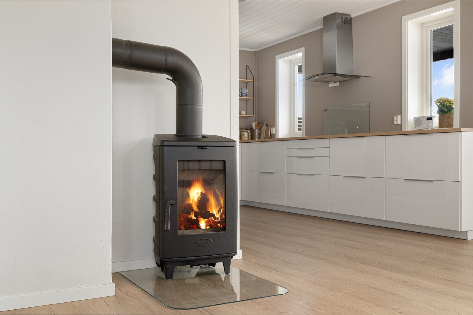 Stilfull vedovn, som står sentralt plassert i stue. Boligen har to vedovner i tillegg til varmepumpe