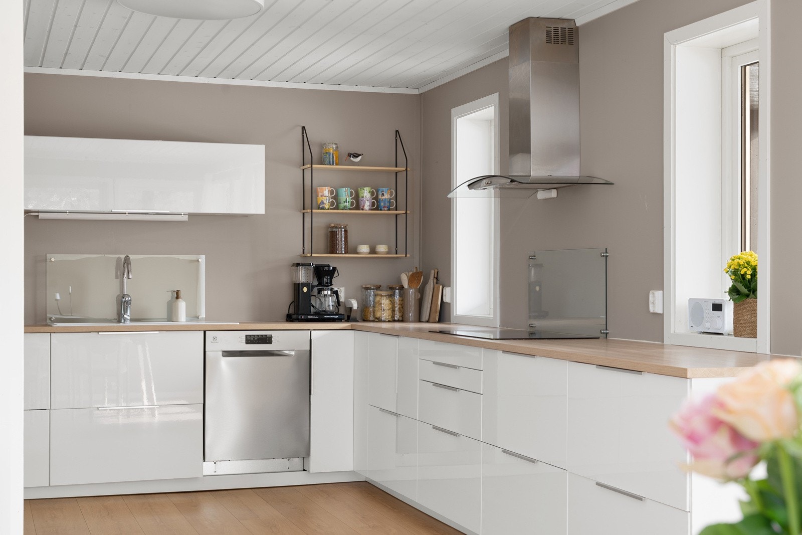 Stilrent kjøkken med glatte fronter og godt med skuffer, skap og benkeplass. Vindu over benk som gir gode arbeidsforhold