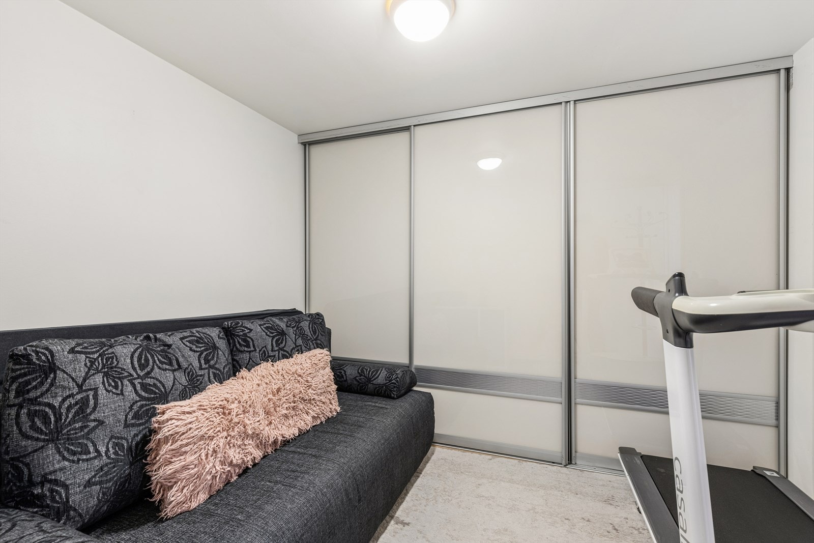 Bod i dag innredet med sovesofa, skyvedører med gode oppbevarings muligheter og tredemølle. Galleribilde
