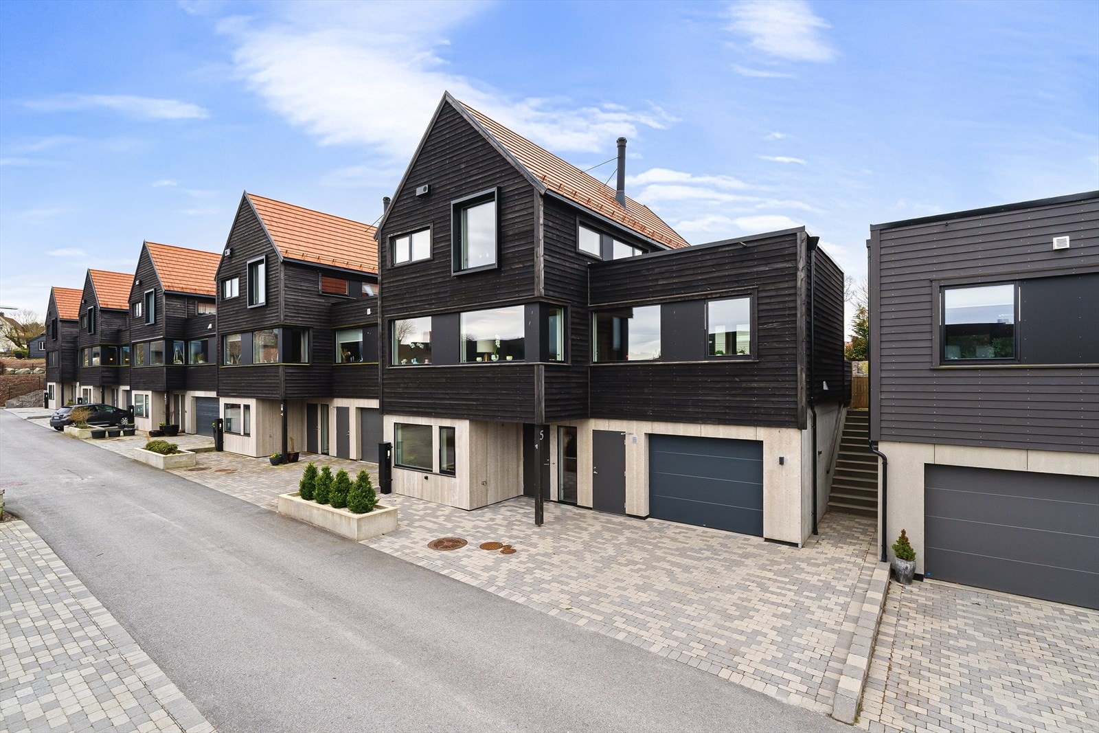 Tomten er ryddig opparbeidet med belegningsstein i gardsrom, skjermet uteområde med terrasse og hage, samt flere bed. Galleribilde