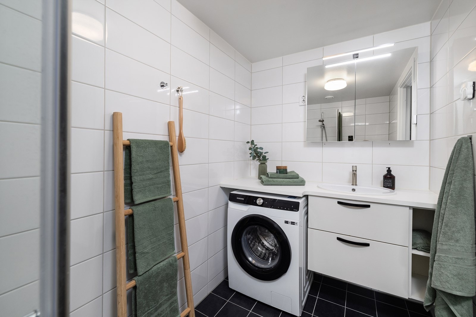 Opplegg for vaskemaskin under en felles benkeplate med servanten. Galleribilde