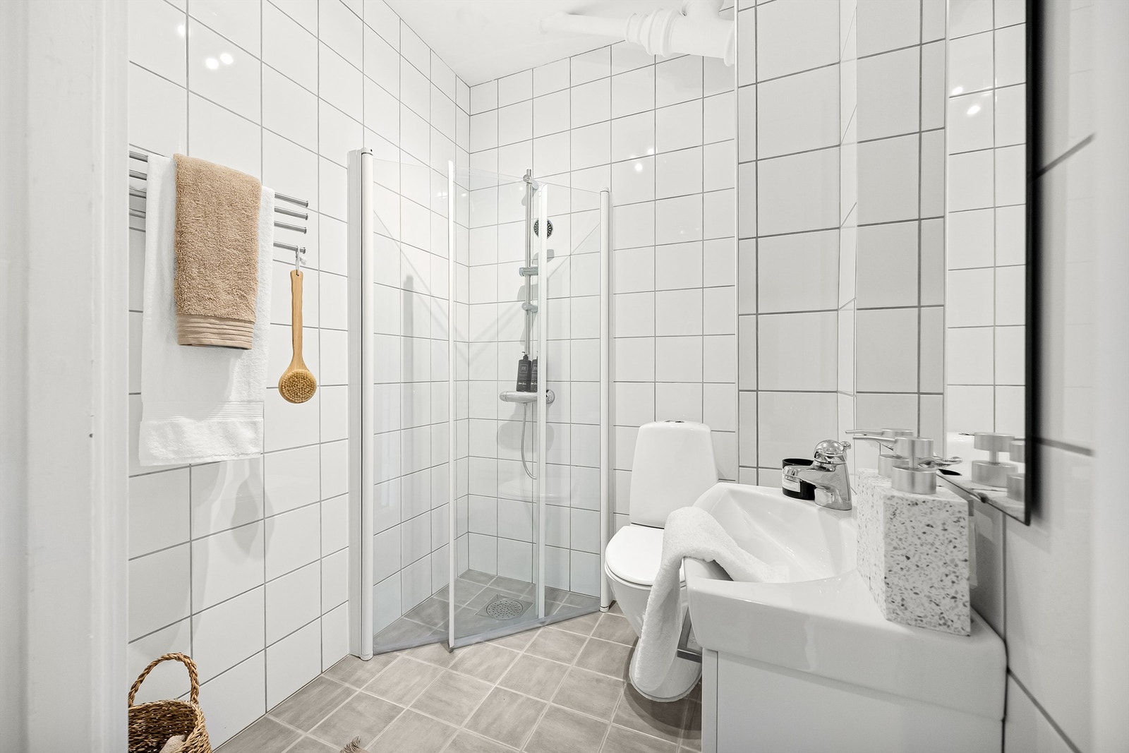 Tidløst bad med flislagt gulv og vegger samt opplegg for vaskemaskin. Galleribilde