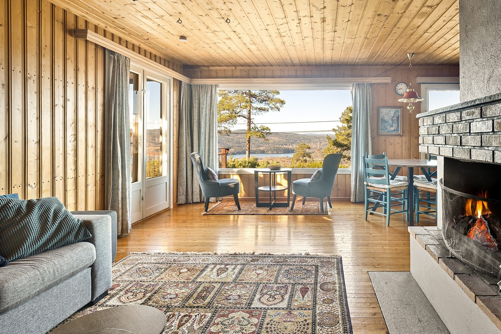 Stuen og kjøkkenet danner et åpent og sosialt hjerte i hytta, med store vindusflater som rammer inn utsikten. Galleribilde