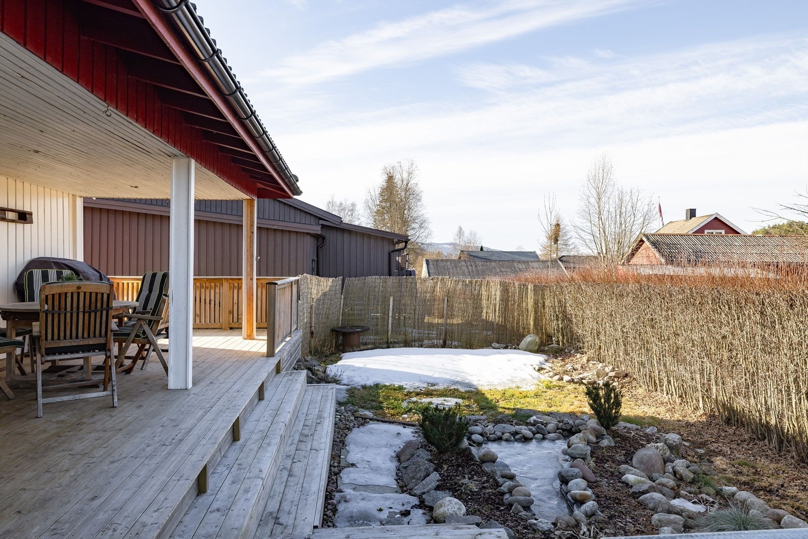Boligen har en koselig hageflekk og en stor terrasse som strekker seg rundt boligen. Galleribilde