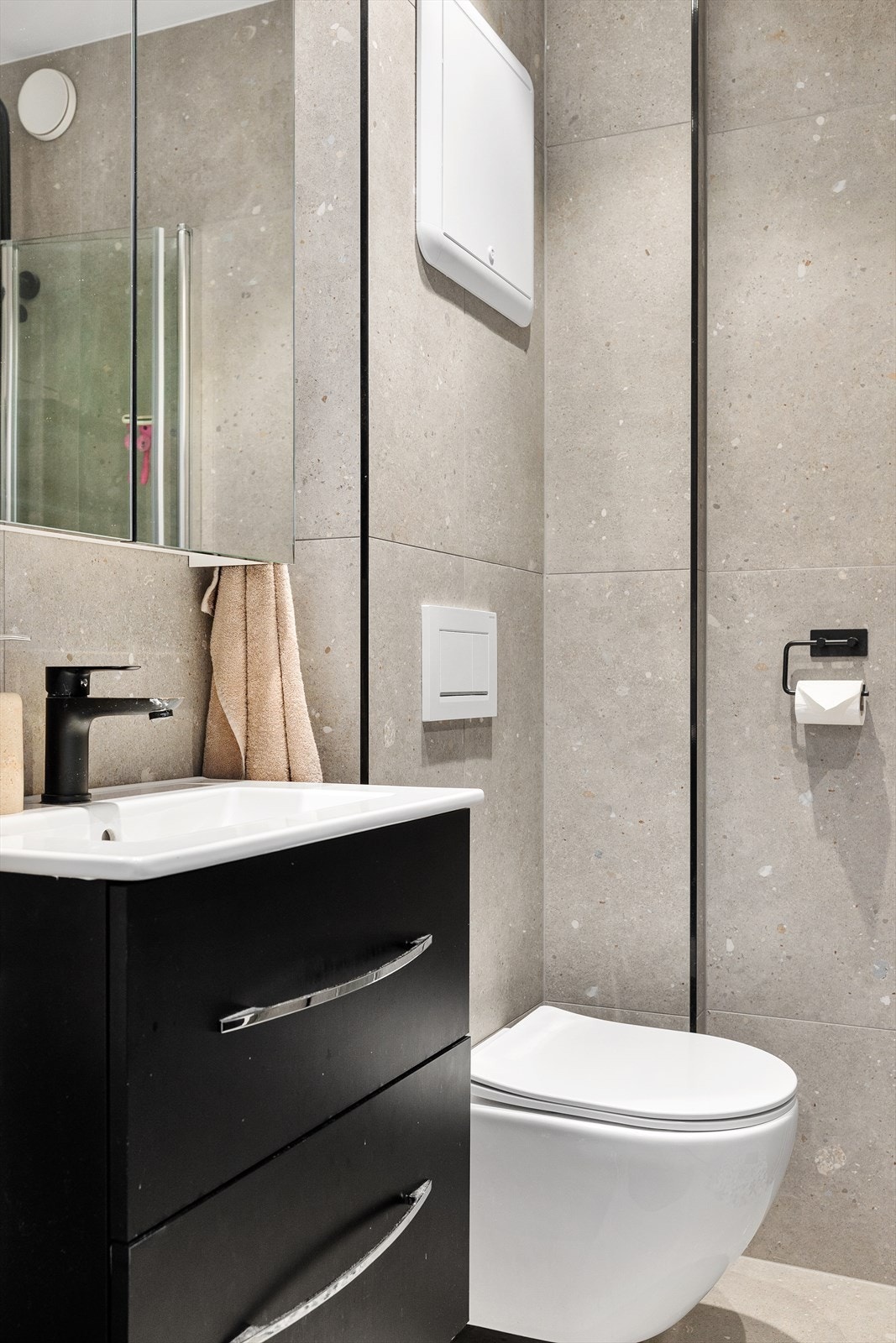 Badet er utstyrt med vegghengt WC, dusjsone med dusjvegger, servant med ettgreps blandebatteri i innredning samt opplegg for vaskemaskin. Galleribilde