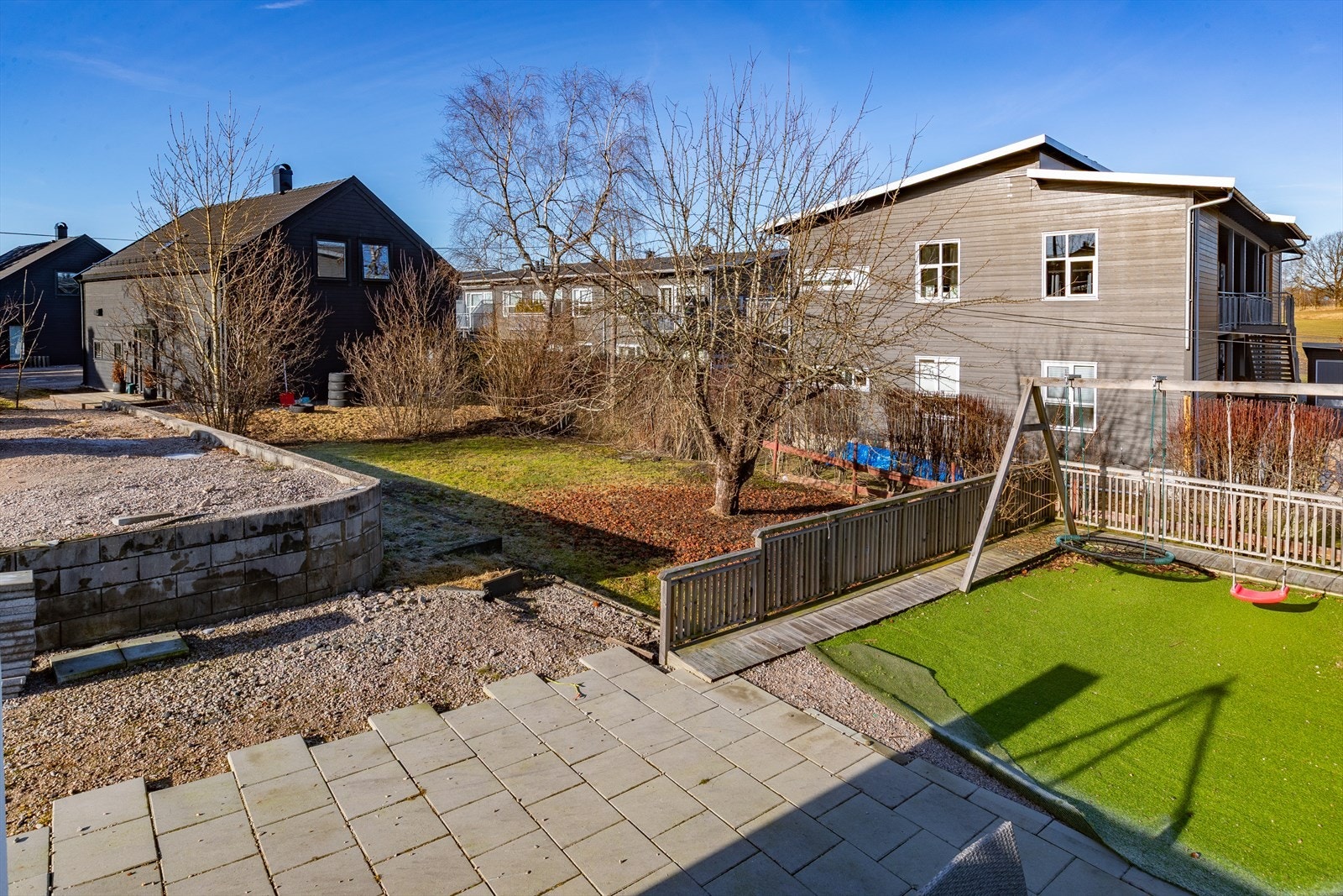 Hagen er delvis opparbeidet med gress og plantebed. Galleribilde