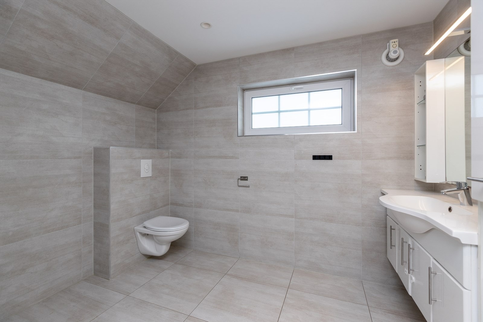 Badet har keramiske fliser på gulv og vegger, samt mekanisk ventilasjon. Galleribilde