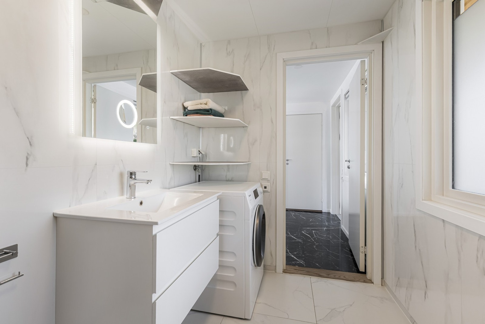 Det fremstår moderne, med fliser på gulv og sokkel samt våtromsplater på veggene. Galleribilde