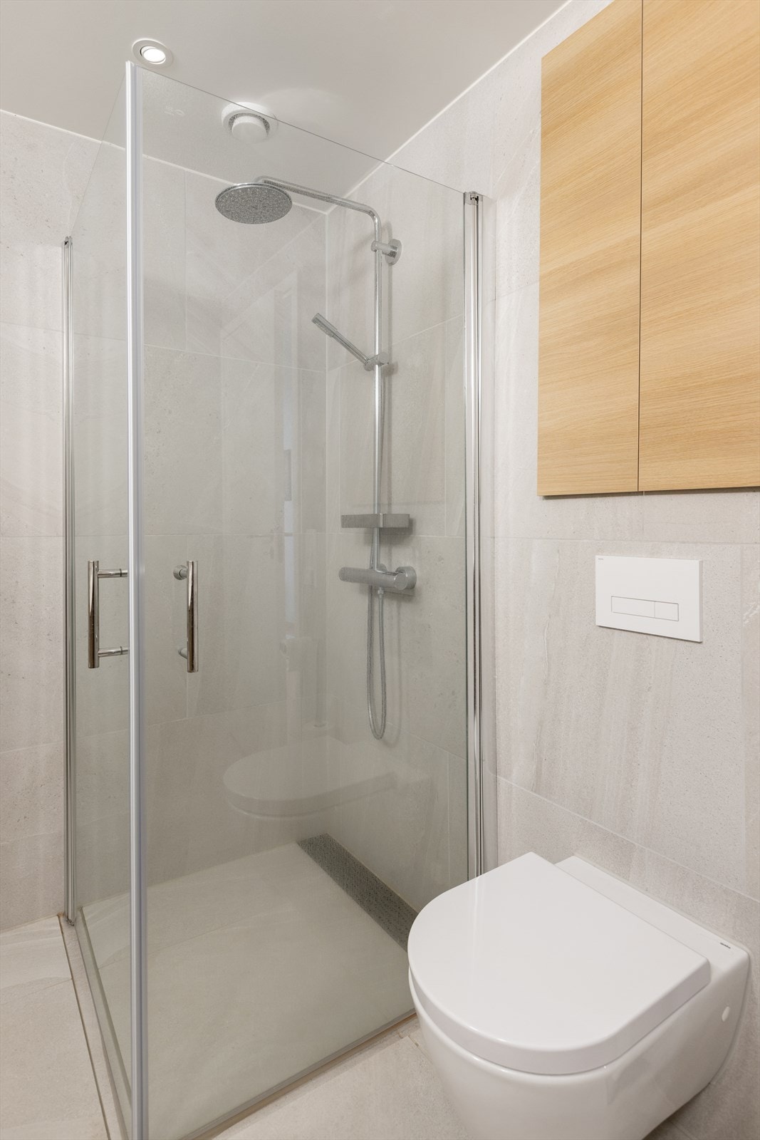 Badet har store lekre fliser i lys utførsel både på vegger og gulv. Galleribilde