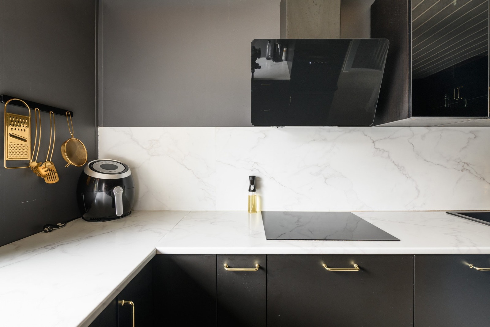 Veggene over benken er kledd med plater som matcher laminatbenkeplaten i marmor-look. Galleribilde