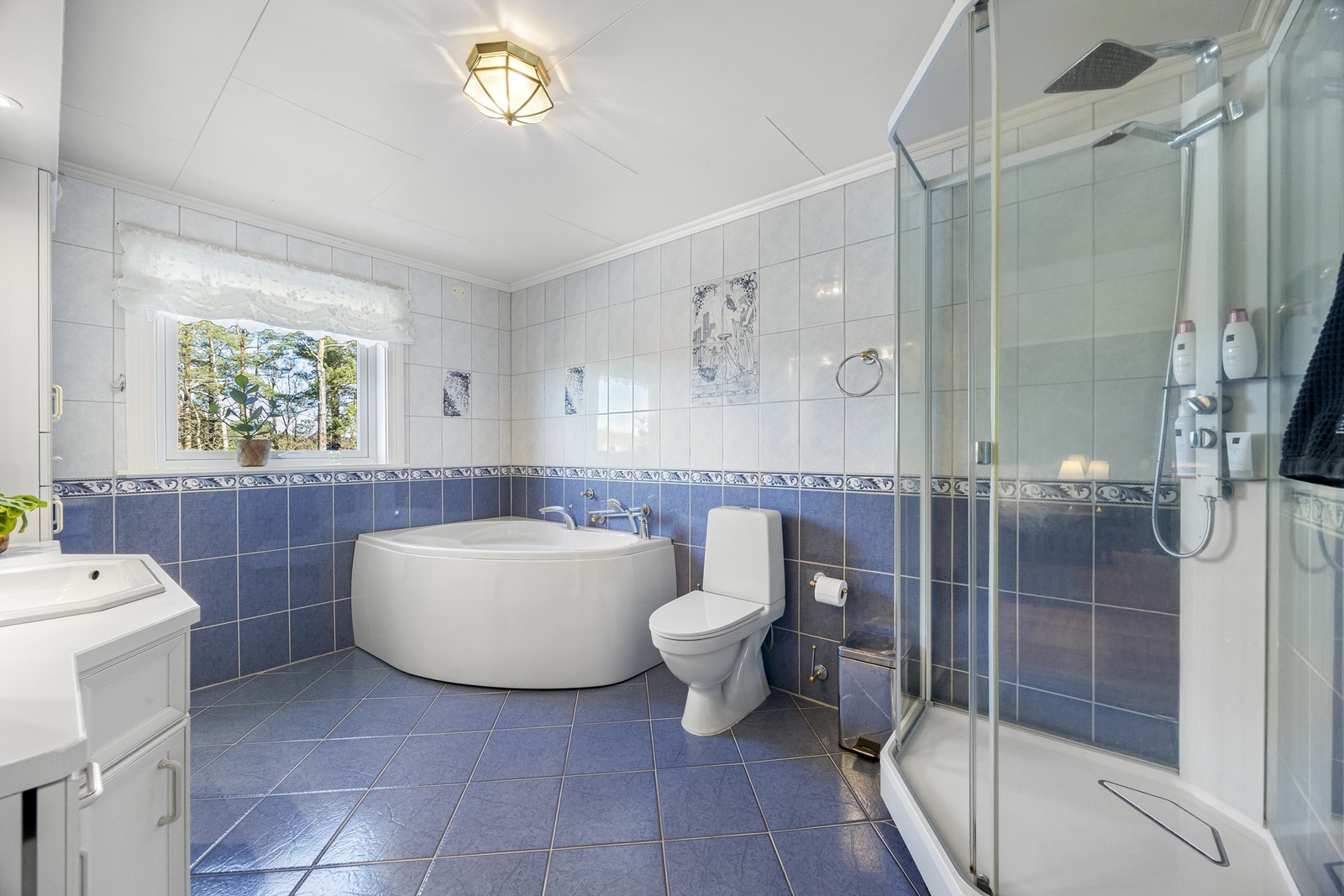 Badet er utstyrt med både badekar og dusjkabinett, samt toalett og servant med innredning. Galleribilde