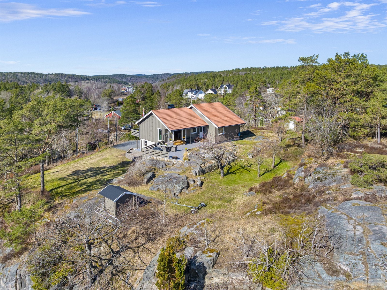 Tomten er preget av svaberg og natur, og gir en usjenert ramme rundt boligen. På eiendommen står også en frittstående garasje på 28 m², oppført i 1986. Galleribilde
