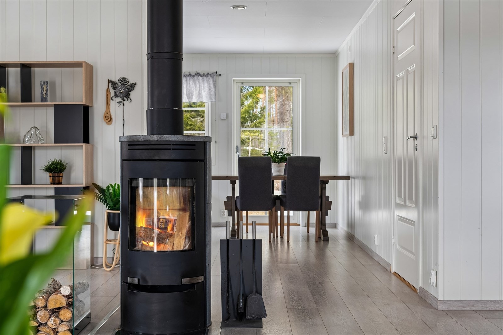 Vedovnen fra ca. 2022 er sentralt plassert i stuen sprer varm atmosfære og hygge i den åpne stue- og kjøkkensonen. Galleribilde