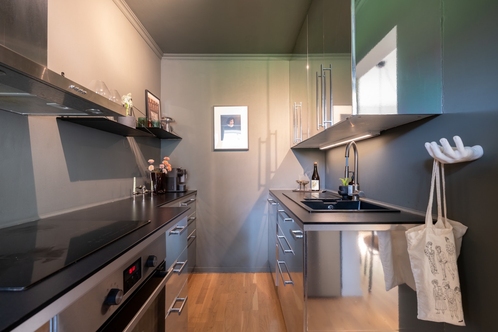 Kjøkkeninnredningen har folierte fronter (opprinnelig høyglans), samt laminat benkeplate med nedfelt kompositt oppvaskkum og nedfelt induksjon koketopp. Galleribilde