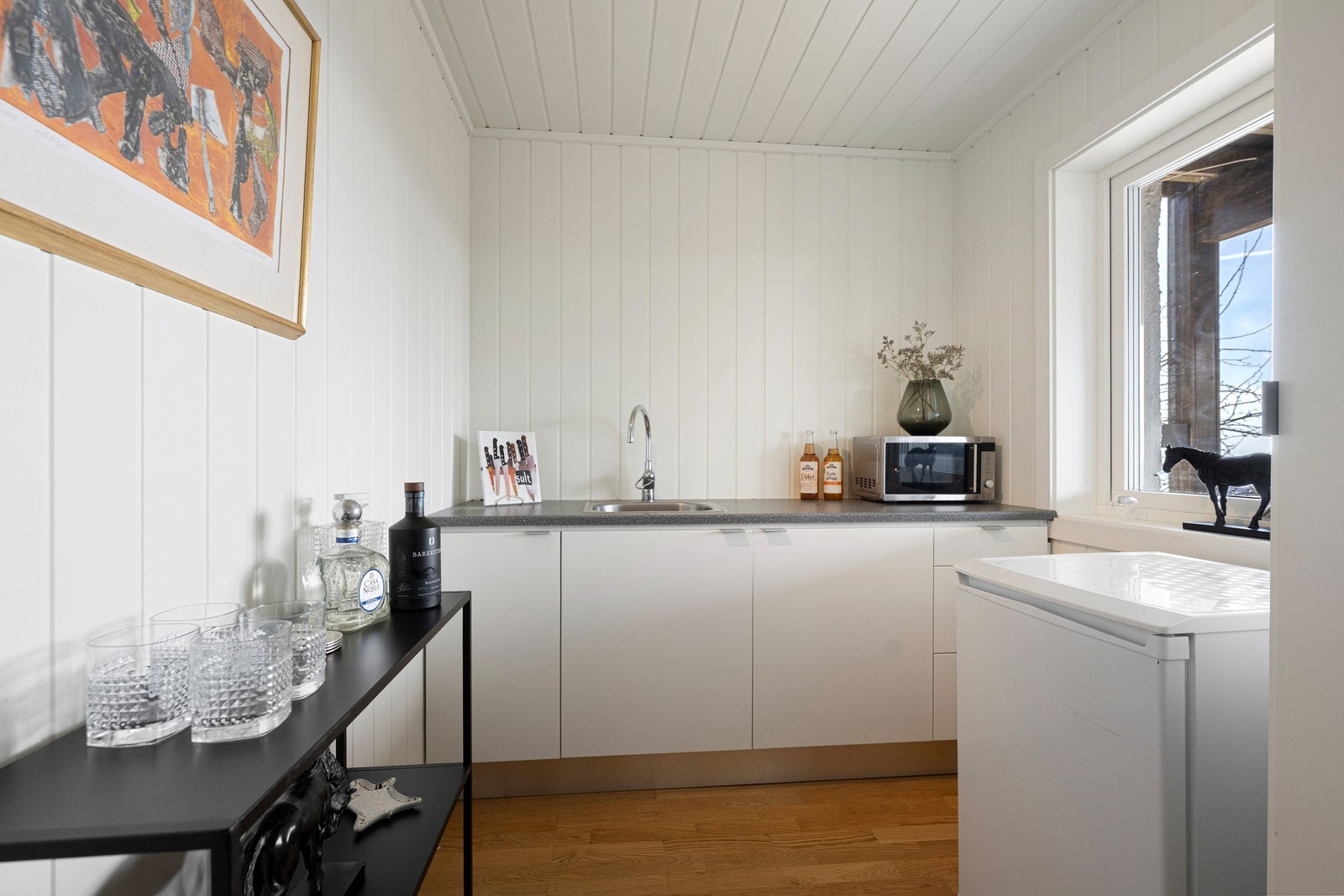 Rommet består av skapinnredning med benkeplate. Det er satt inn et frittstående kjøleskap. Galleribilde
