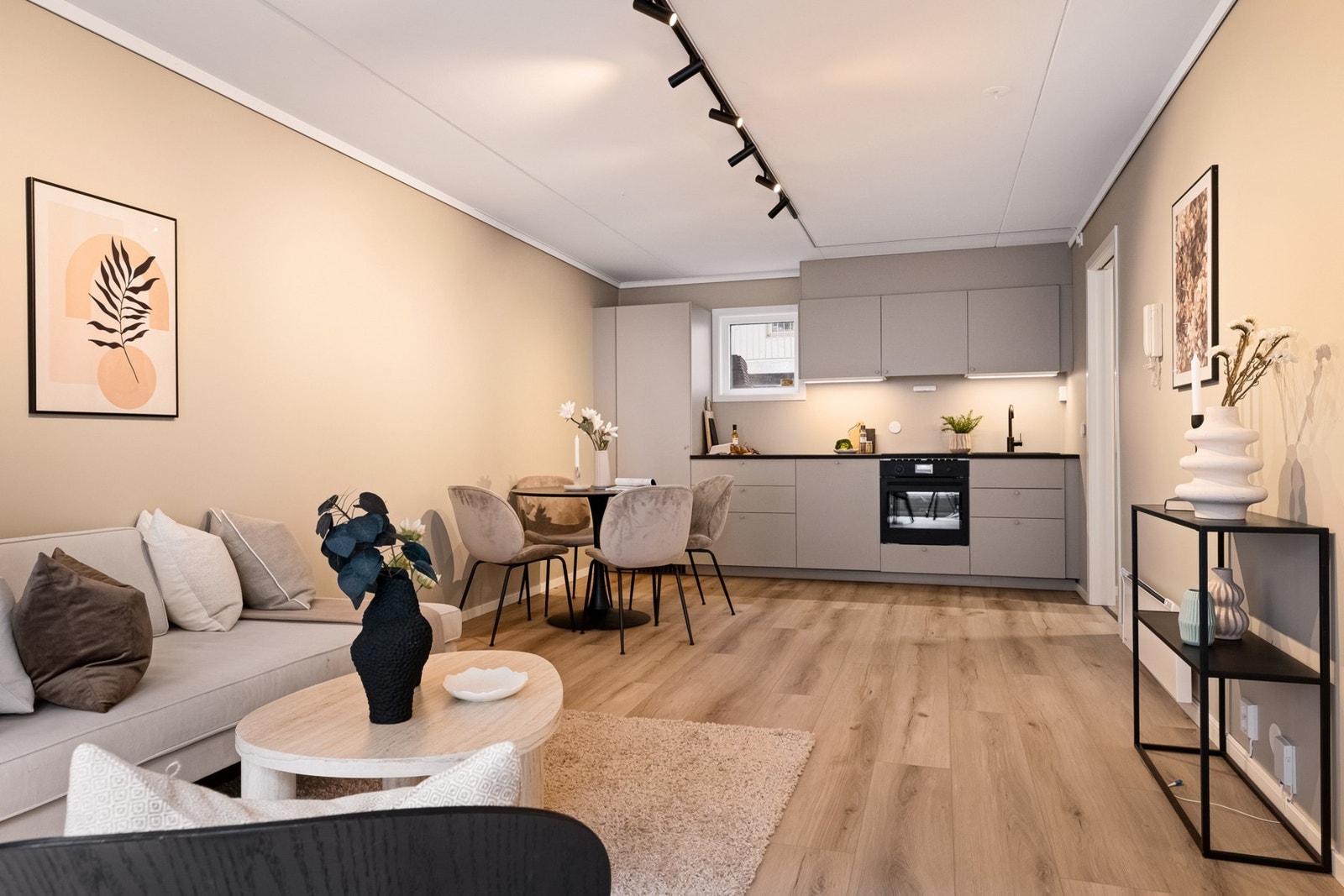 Pent oppholdsrom med praktisk planløsning mot kjøkkenet; store flater og nymalte overflater gir en luftig og innbydende atmosfære. Galleribilde