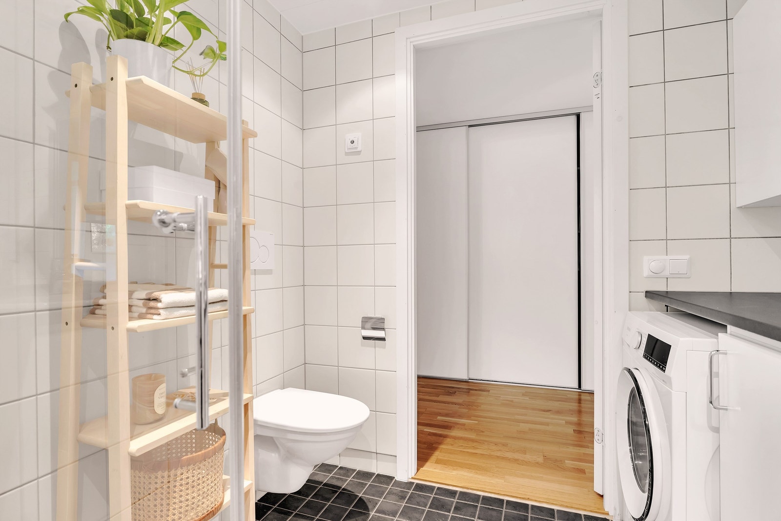 Flislagt gulv med gulvvarme og flislagte vegger, samt vegghengt toalett. På bade er det også praktisk opplegg for vaskemaskin. Galleribilde