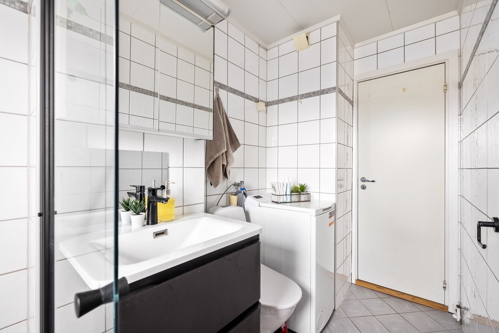 Badet er utstyrt med dusjhjørne, servantinnredning, toalett og har opplegg for vaskemaskin. Galleribilde