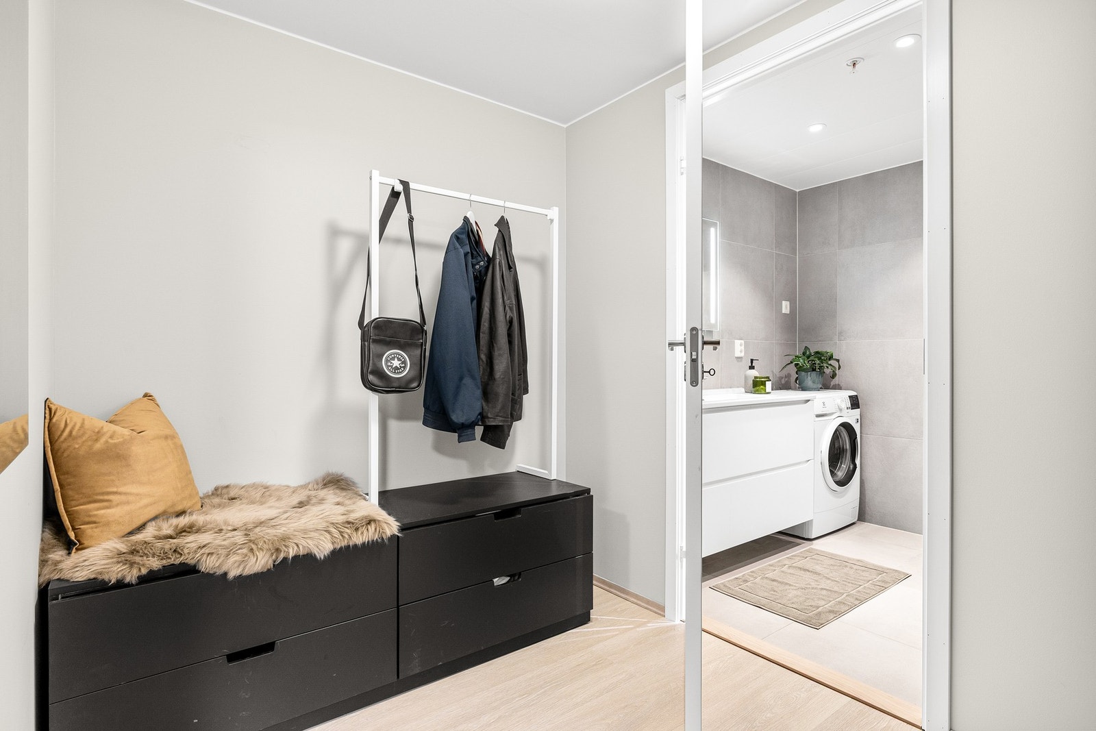 Den romslige entréen på 4,7 kvm har god plass til oppbevaring av sko og oppheng av yttertøy. Her har du direkte adkomst til både baderom og stue/kjøkken. Galleribilde