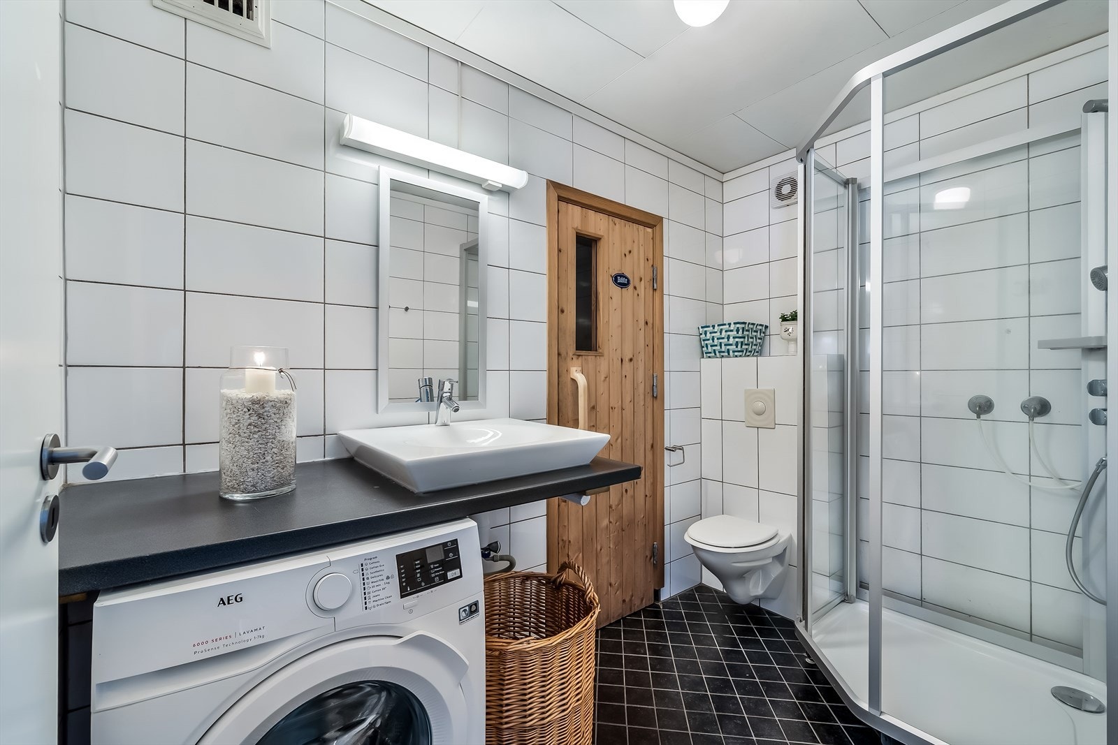 Baderom i 1.etasje med WC, dusj, servant og opplegg for vaskemaskin. Inngang til badstue. Galleribilde