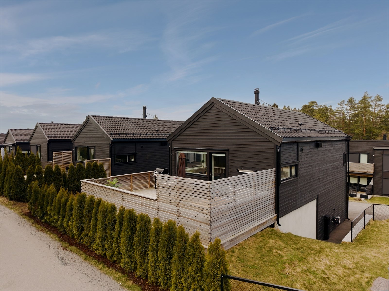 Boligen ligger på enden og har en terrasse som er skjermet med levegger for privatliv og en liten lettstelt hage. Foto; Studio 183 - Stig Heltorp Galleribilde