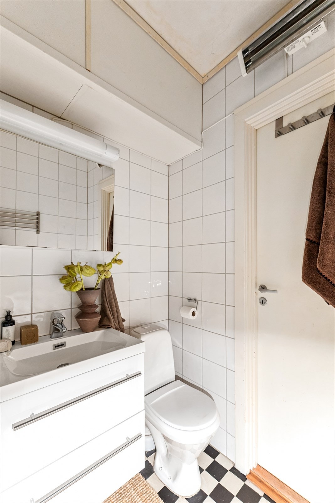 Badet er innredet med frittstående toalett, dusjkabinett, innredning med servant med blandebatteri, overskap med speil og lys samt opplegg for vaskemaskin. Galleribilde