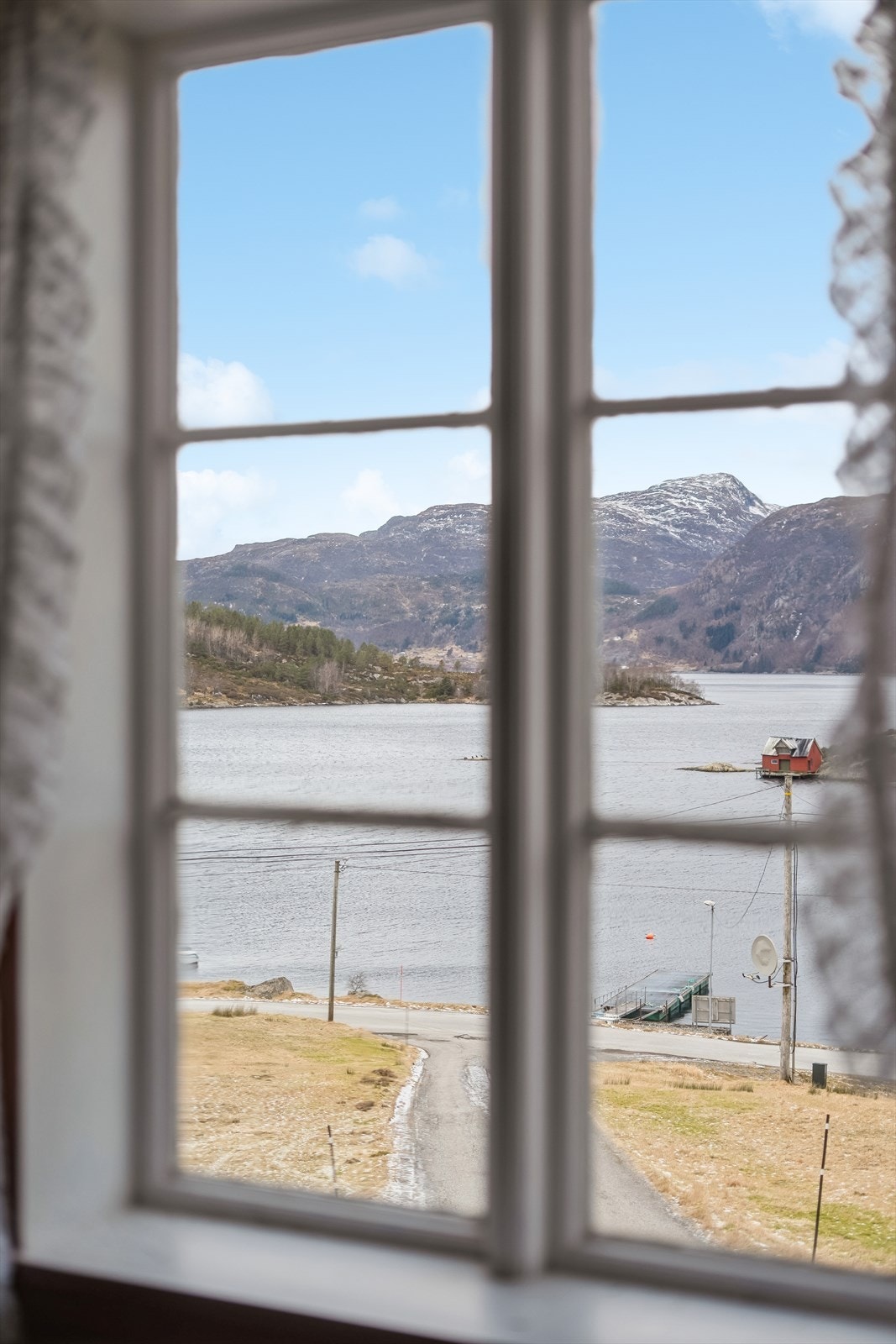 Frå vindauga ser ein utover det kystnære landskapet i Rugsund. Galleribilde